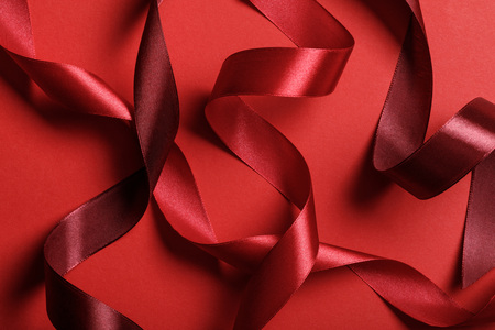 close up of silk burgundy and red ribbons on red backgroundの写真素材