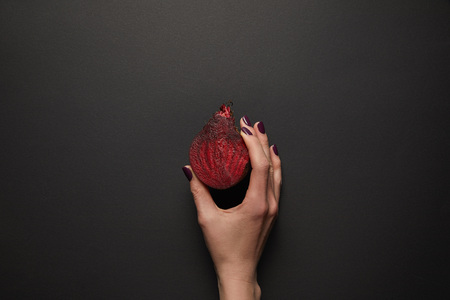 Partial view of woman holding cut beet on black surfaceの写真素材