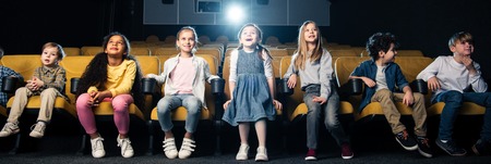 panoramic shot of multicultural friends spending time in cinema togetherの写真素材