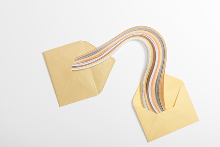 top view of yellow envelopes with multicolored rainbow on grey backgroundの写真素材