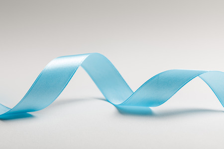 close up of wavy blue silk ribbon on grey backgroundの写真素材