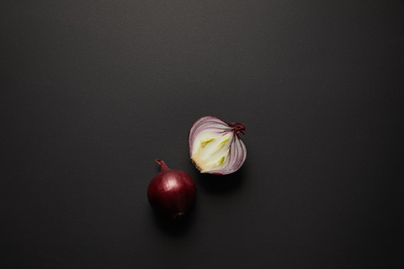 Top view of fresh cut onion on black surfaceの写真素材