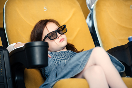 selective focus of dreamy child in 3d glasses sitting in cinema seatの写真素材