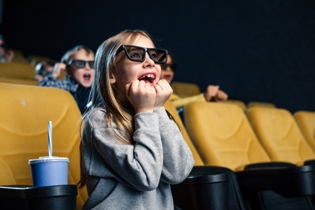 excited multicultural friends in 3d glasses watching movie in cinema togetherの写真素材