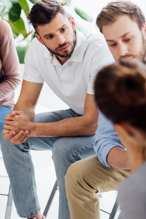 selective focus of men sitting during group therapy sessionの写真素材