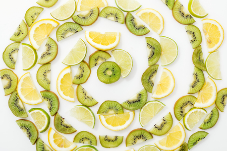 Flat lay with cut lemons, limes and kiwis on white surfaceの写真素材