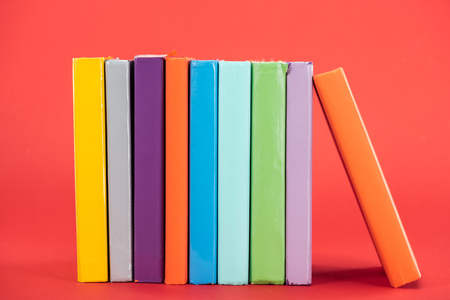 Colorful books with bright hardcovers on red surfaceの写真素材