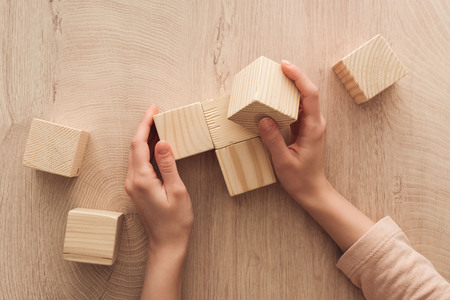 cropped view of female hands near blank wooden cubes