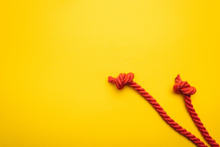 red and long ropes with twisted knots isolated on orange
