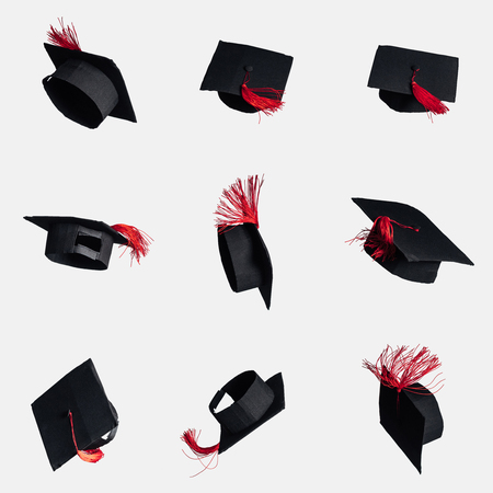 Black academic caps with red tassels isolated on whiteの写真素材