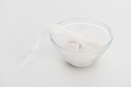 rice in cheesecloth in glass bowl on grey backgroundの写真素材