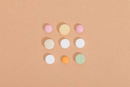 Flat lay with colorful pills on brown surfaceの写真素材