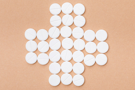 Flat lay with white pills on brown surfaceの写真素材