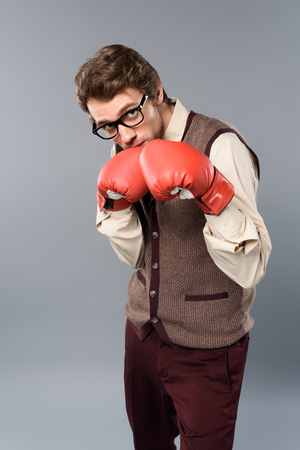 serious man in glasses and boxing gloves on grey backgroundの写真素材