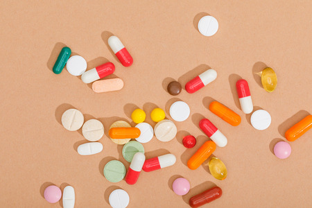 Top view of colorful pills on brown surfaceの写真素材
