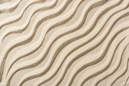 top view of beige sandy backdrop with smooth wavesの写真素材