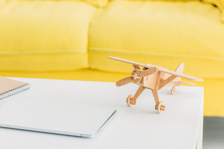 Wooden plane model near laptop on white table at homeの写真素材