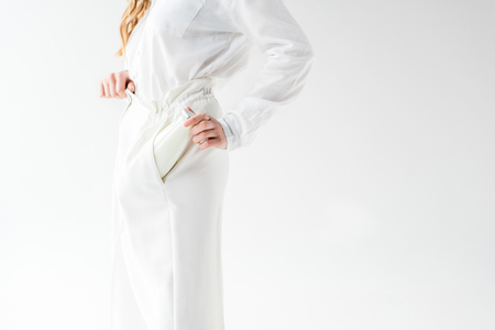 Cropped view of woman putting bottle of milk in pocket on white backgroundの写真素材