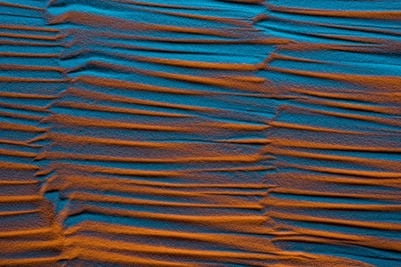 Top view of textured sandy background with color filter and abstract waves