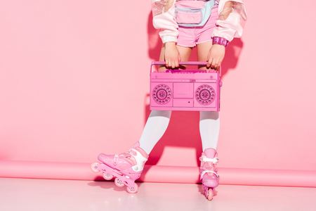 Cropped view of girl in long socks holding retro boombox on pink backgroundの写真素材