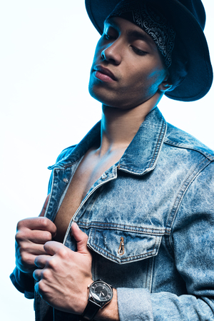 Handsome stylish mixed race man in denim and hat posing isolated on white backgroundの写真素材