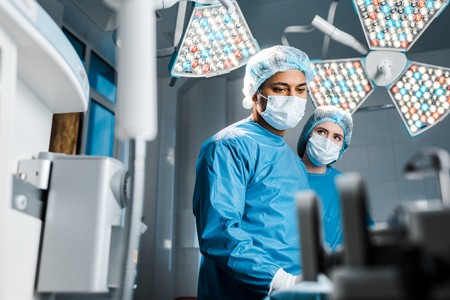 Selective focus of doctor and nurse in uniforms and medical masksの写真素材