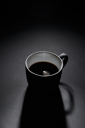 Cup of black coffee on dark textured surfaceの写真素材