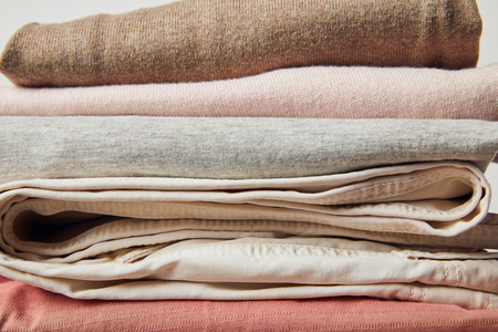 Close up view of stack of folded ironed clothes on grey backgroundの写真素材