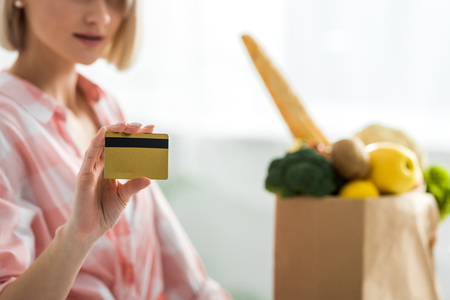 Cropped view of woman holding credit card near groceriesの写真素材