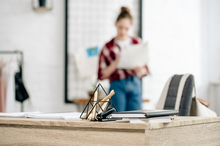 Selective focus of teenager in jeans and table with notebooksの写真素材