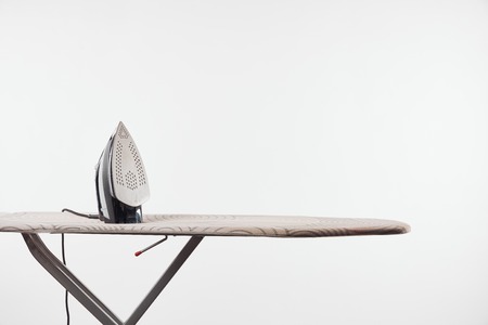 Ironing board with dark legs and iron isolated on white backgroundの写真素材