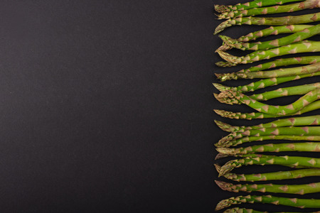 top view of green organic asparagus on black backgroundの写真素材