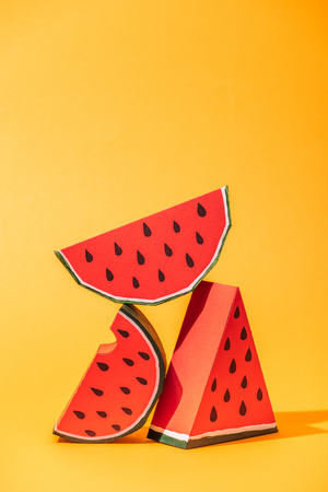 red paper watermelon slices on orange with copy spaceの写真素材