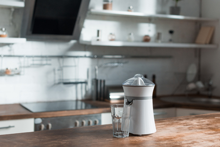 sunlight in kitchen with juicer and glass on wooden surfaceの写真素材