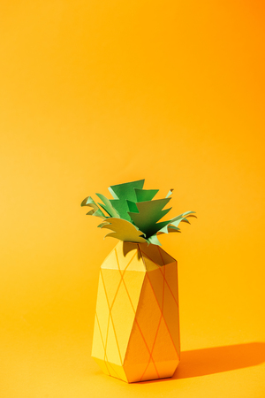 handmade paper yellow pineapple on orange with copy spaceの写真素材