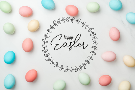 top view of multicolored chicken painted eggs on grey background with happy Easter lettering in circle frameの写真素材
