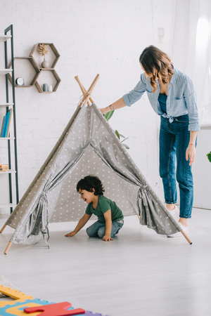 Full length view of woman standing near son in grey wigwamの写真素材