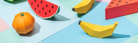 panoramic shot of handmade cardboard fruits on multicolored paperの写真素材
