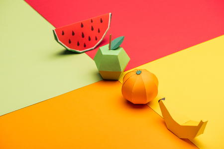 origami watermelon, apple, tangerine and banana on colorful paperの写真素材