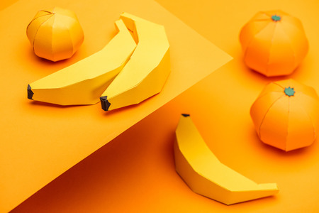 Selective Focus of origami bananas and tangerines on orangeの写真素材