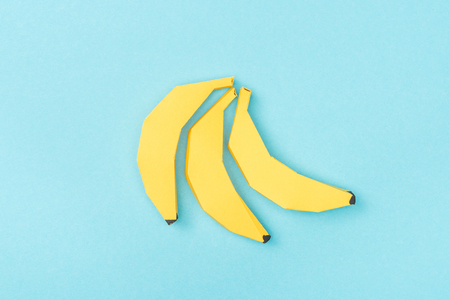 Top view of yellow paper bananas isolated on blue backgroundの写真素材