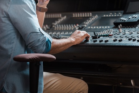 Cropped view of mixed race sound producer working at mixing consoleの写真素材