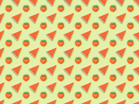 Top view of textured pattern with handmade paper strawberries and watermelon slices isolated on green backgroundの写真素材