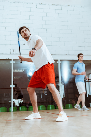 Full length view of two sportsmen playing squash in four-walled courtの写真素材