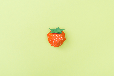 Top view of handmade paper strawberry isolated on green backgroundの写真素材