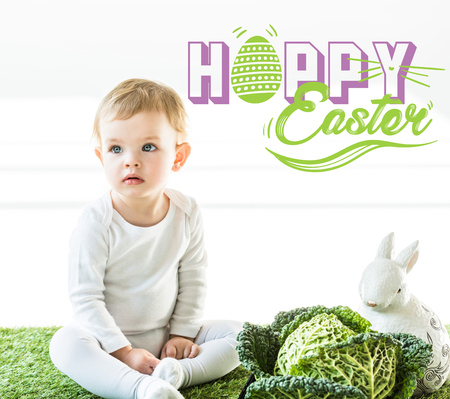 Child sitting near savoy cabbage and decorative bunny on green grass with happy Easter lettering