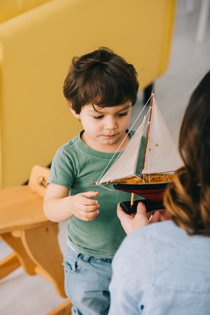 Cropped view of mother and little son with toy shipの写真素材