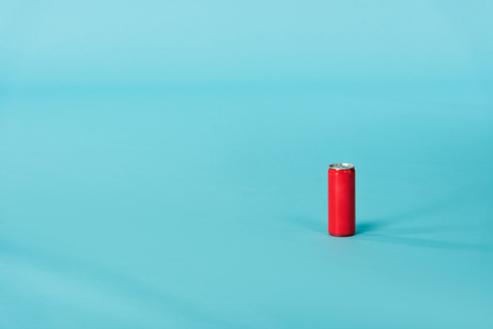Red aluminum can with beverage on blue surface backgroundの写真素材