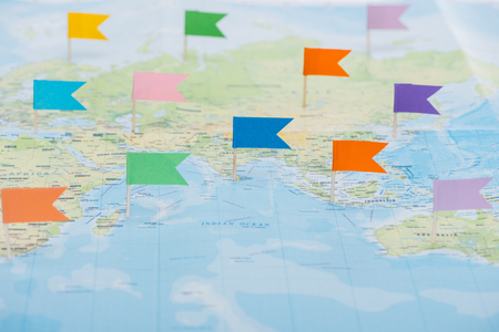 Colorful stationery flags pinned on world map