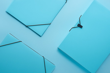 Minimalistic background with paper binders isolated on blue backgroundの写真素材